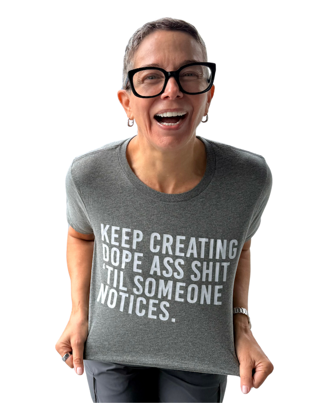 Laughing woman with short hair and glasses wearing T-shirt that says "Keep creating dope ass shit 'til someone notices"